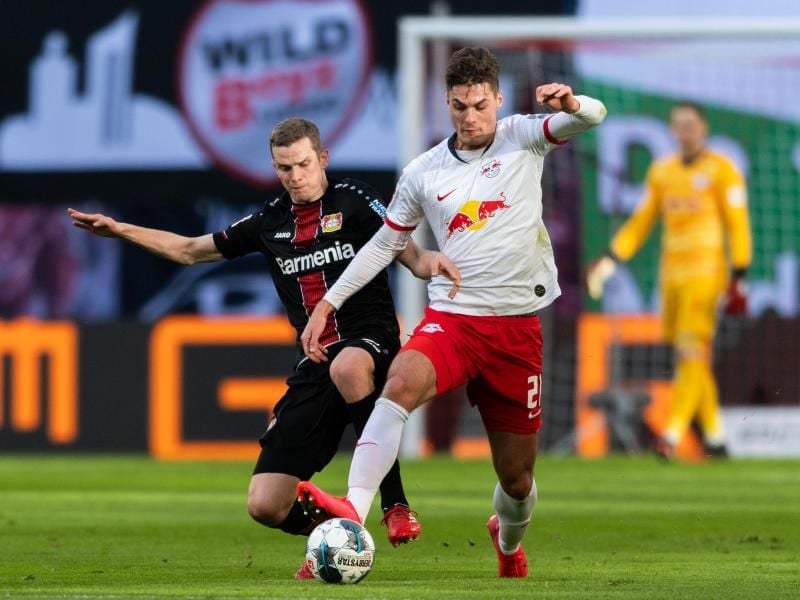 Leverkusens Sven Bender (l) geht gegen Leipzigs Patrik Schick von hinten in den Zweikampf. Foto: Robert Michael/dpa-Zentralbild/dpa