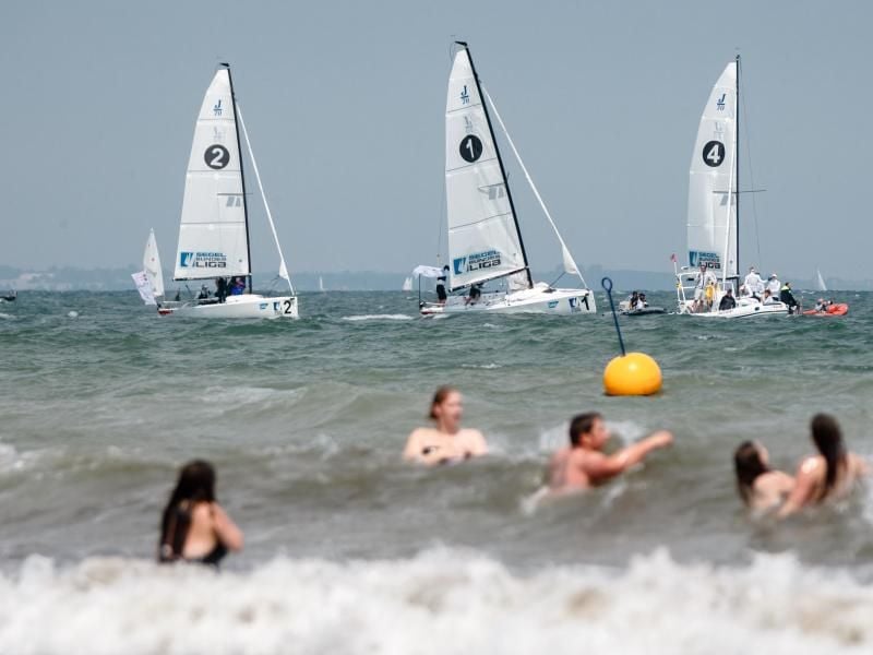 Segelboote und Badegäste sind während der Travemünder Woche zu sehen. Foto: Markus Scholz/dpa
