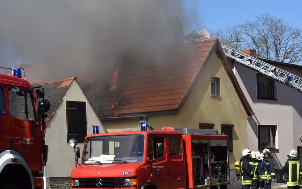 Ein Einfamilienhaus in Klein Schierstedt brennt. Die Flammen schlagen aus dem Dach heraus.
