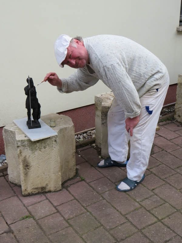 Mit dem Pinsel geht Ulrich Janku über die fertige Plastik. Im Auftrag unserer Zeitung hat der Zwintschönaer, der mit Naumburg eng verbunden ist, die Figur des diesjährigen Tageblatt/MZ-Wenzelspreises gefertigt.