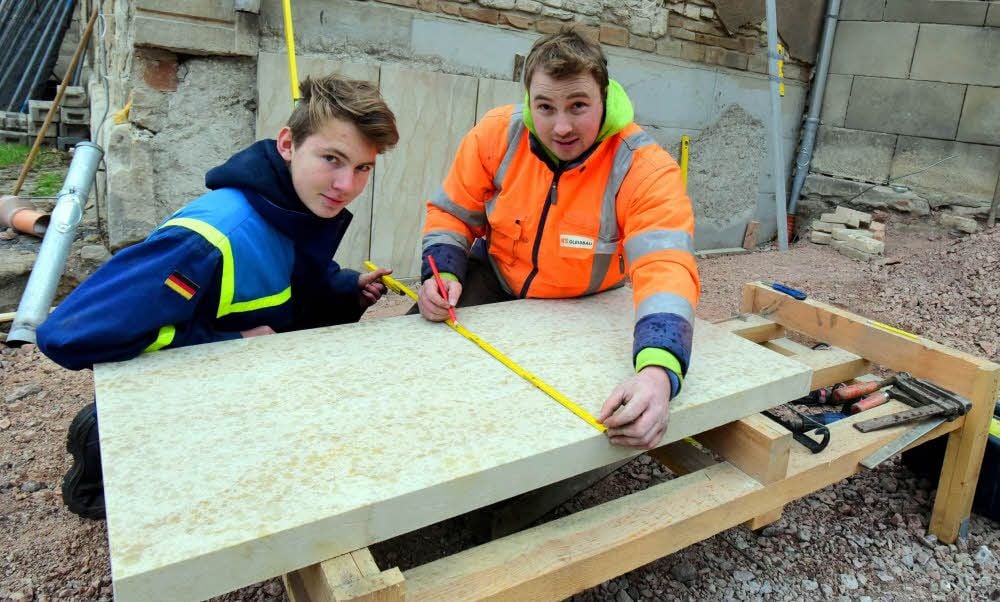 Niclas Knesebeck (links) und Christoph Schmoranzer beim Ausmessen der Steinplatten für den Sockel der Schlossmauern.