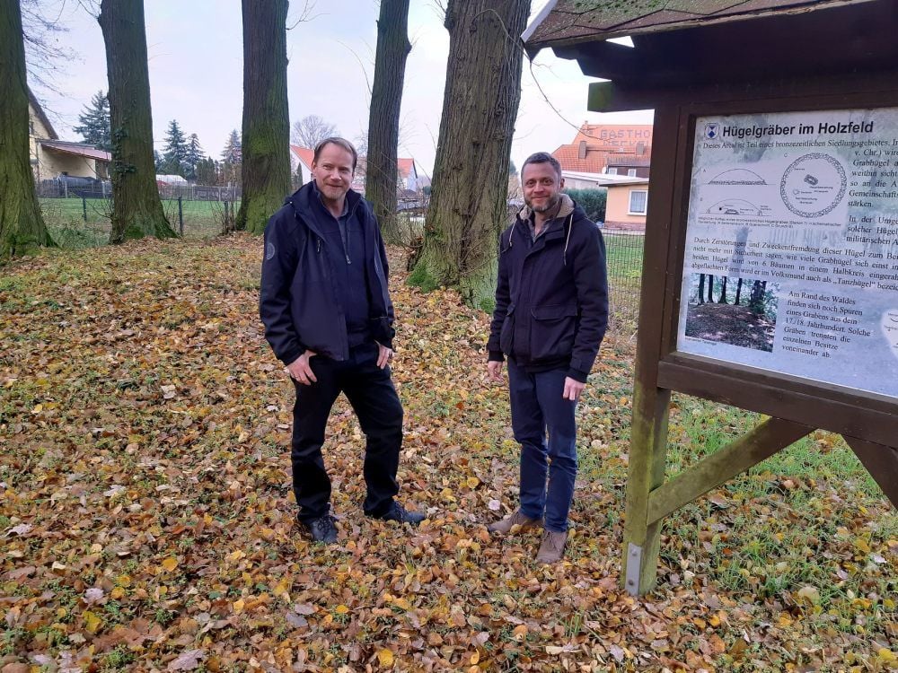 Matthias Henniger (l.) und Gutenborns Bürgermeister Stefan Leier am Hügelgrab in Giebelroth. Die Schautafel wurde vom Geo-Naturpark bezahlt.