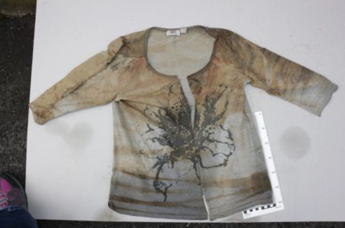 Diese graue Shirt mit vorderseitigen Fantasiemotiv und Strasssteinen trug die Frau.