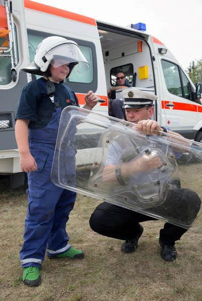 Von Polizeioberkommissar Heinz Geisler ließ sich Jungfeuerwehrmann Philipp Kilian aus Schweinitz Anwendungsmöglichkeiten der Ausrüstungsgegenstände der Polizei zeigen.