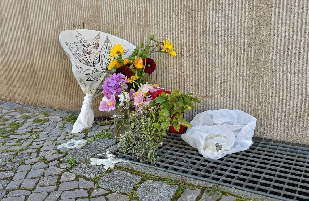 Blumen und Kerzen wurden in der Straße abgelegt.