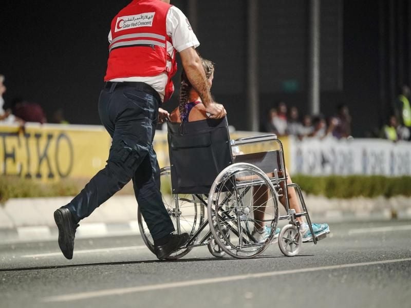 Nur 40 der 68 gestarteten Teilnehmerinnen kamen beim Marathon in Doha ins Ziel: Ein Sanitäter bringt eine erschöpfte Läuferin von der Strecke. Foto: Michael Kappeler