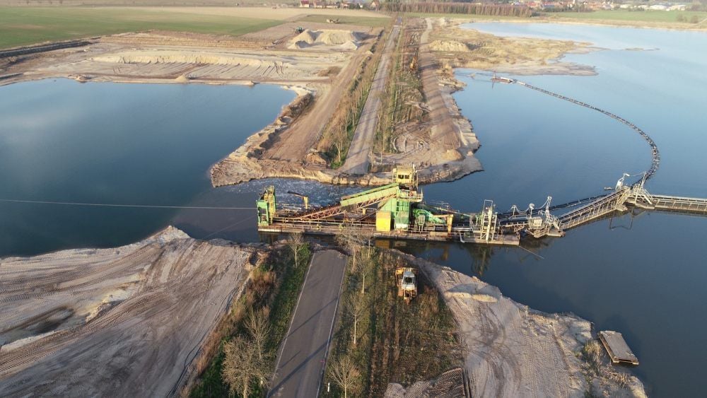 Die entscheidende Phase vor einigen Wochen in dem anspruchsvollen Projekt: Der schwimmende Eimerkettenbagger sorgt bei Steinsdorf selbst für seinen Umzug in ein neues Abbaufeld auf der anderen Straßenseite.