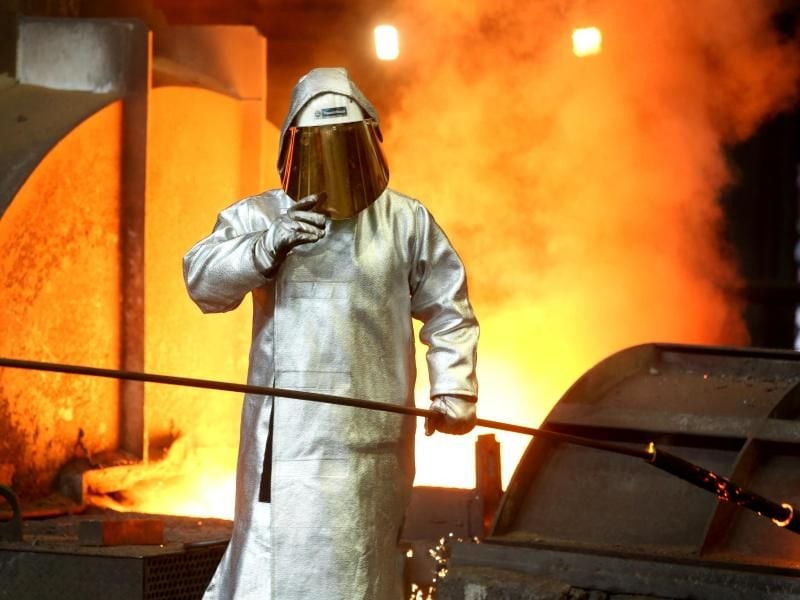 Ein Stahlarbeiter prüft am Hochofen 8 bei ThyssenKrupp in Duisburg die Stahlqualität nach dem Abstich. Foto: Roland Weihrauch/Illustration