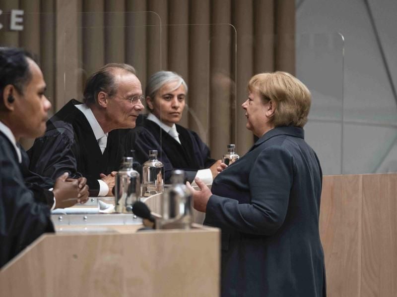 Angela Merkel (Martina Eitner-Acheampong, r), Bundeskanzlerin a.D., im Gespräch mit den Richtern in einer Szene des Justizdramas "Ökozid". Foto: Julia Terjung/rbb/zero one film/ARD/dpa