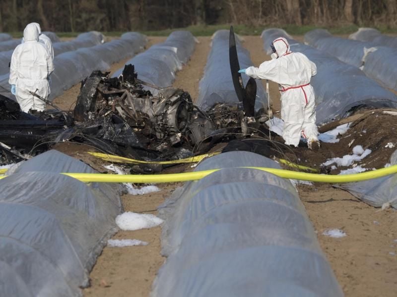 Beamte der Kriminalpolizei und Luftfahrtexperten untersuchen das Wrack des abgestürzten Geschäftsflugzeuges. Foto: Boris Roessler/Archiv