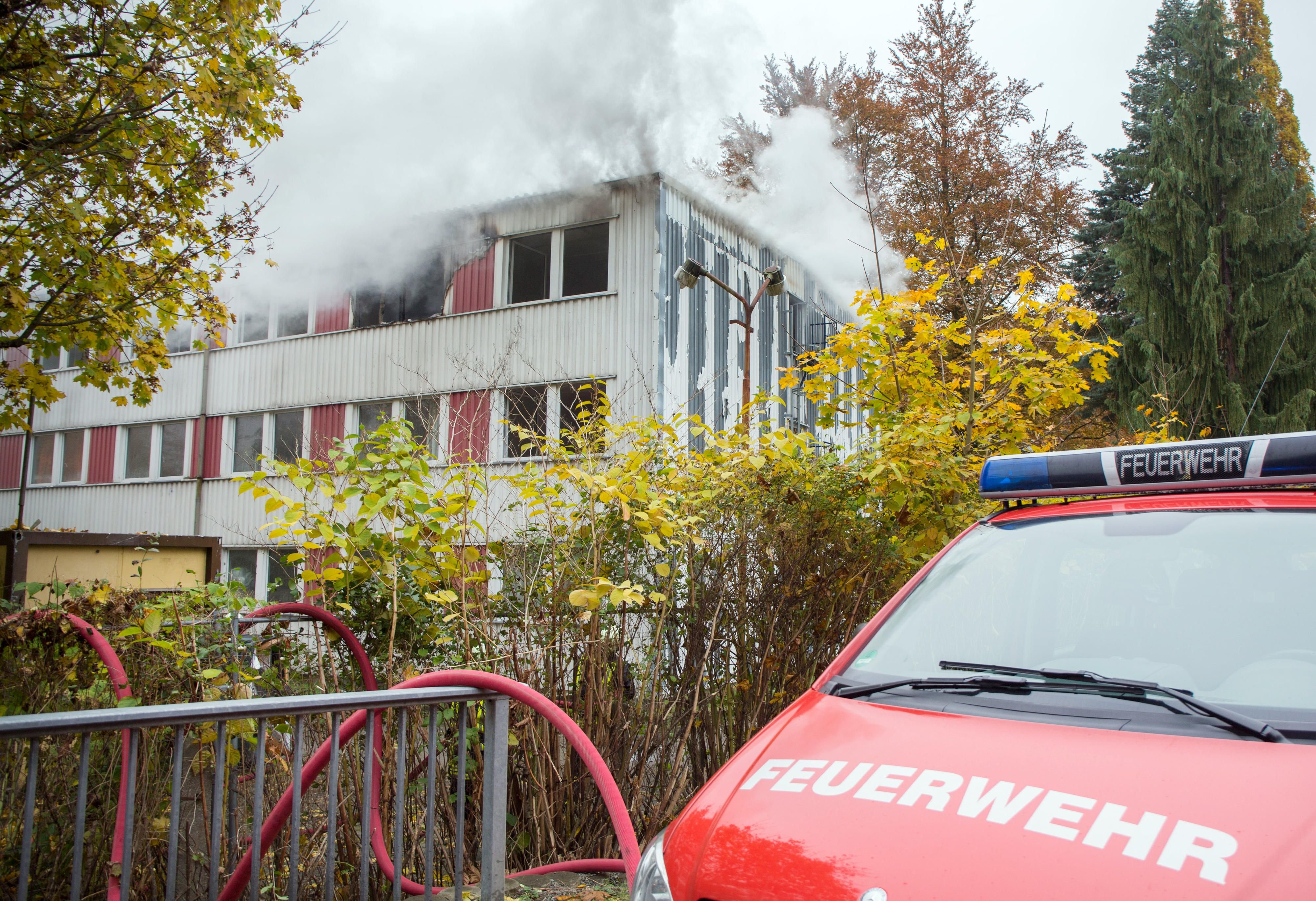 Die Feuerwehr löscht am 28.10.2016 einen Brand in einer Asylunterkunft in Drebach (Sachsen).