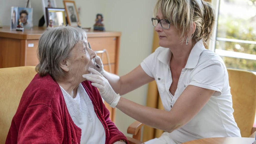 Dorothea Schmidt passt bei der 81-jährigen Gisela Künstler ein Gebiss an.