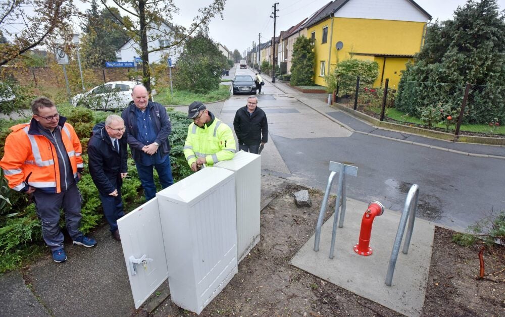 Rüdiger Nathrath (gelbe Weste) erklärt den Anwesenden die Funktionsweise der neuen Zapfstelle am Ende der Paupitzscher Straße.