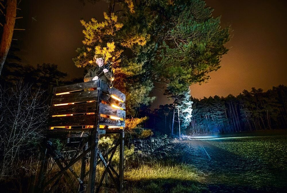 Von seinem für das Foto ausgeleuchteten Hochstand aus hat Gerhard Paul das Feld vor sich im Blick. Gemeinsam mit zwei weiteren Jägern betreut er 1.080 Hektar Land.
