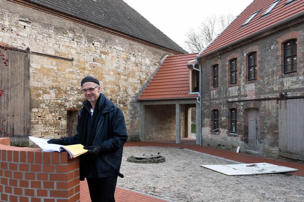 Mühlenbesitzer Karsten Liebmann steht im neu gestalteten Innenhof. Im Gebäude rechts entstehen Ferienwohnungen.