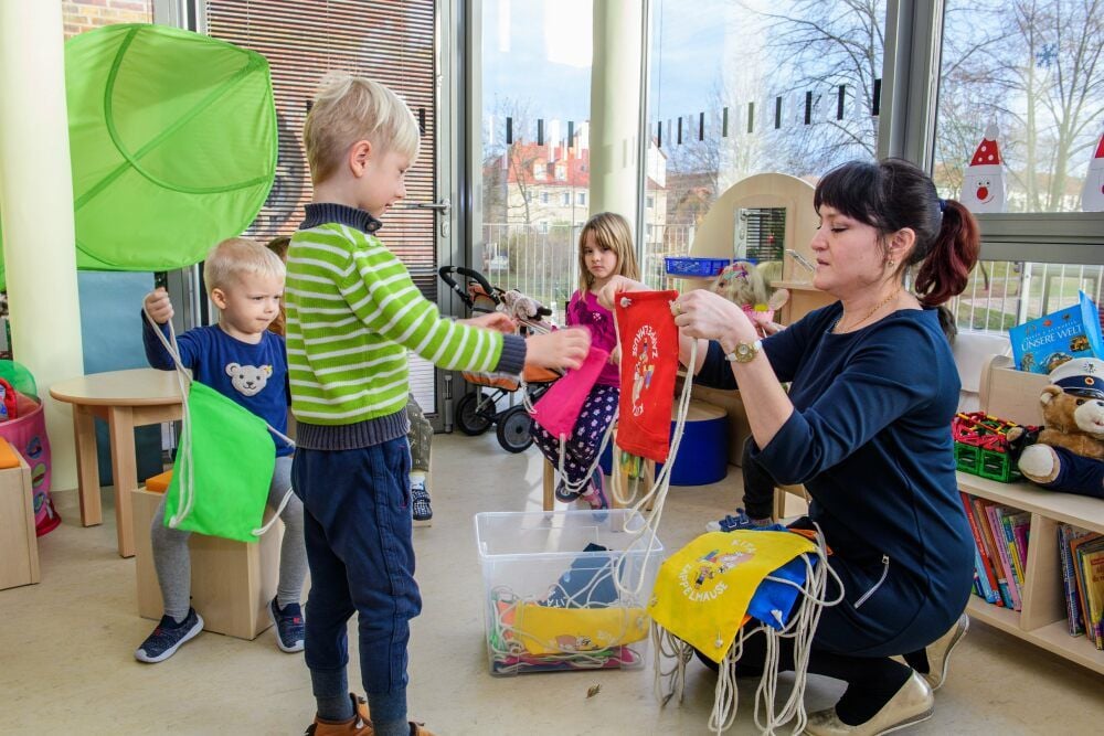 Kita-Leiterin Irina Kolman übergibt Turnbeutel als Willkommensgeschenke der Stadt.