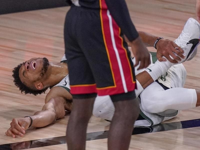 Giannis Antetokounmpo von den Milwaukee Bucks liegt verletzt auf dem Spielfeld. Foto: Mark J. Terrill/AP/dpa
