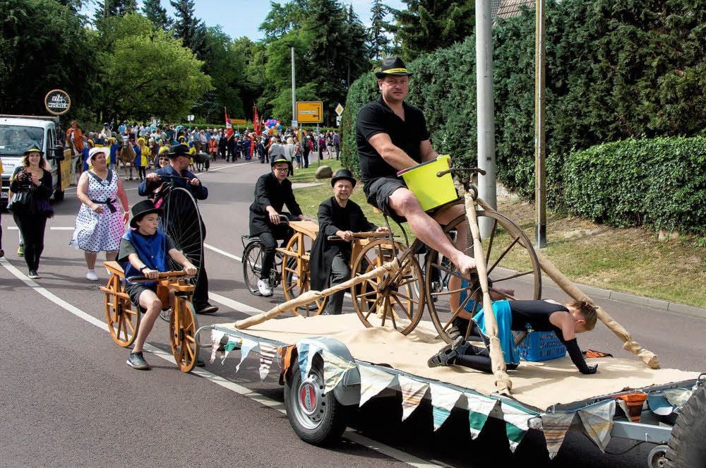 Mitglieder des Müchelner Hallenradsport-Vereins demonstrieren mit Holzrädern und einem Hochrad die Geschichte der Drahtesel.