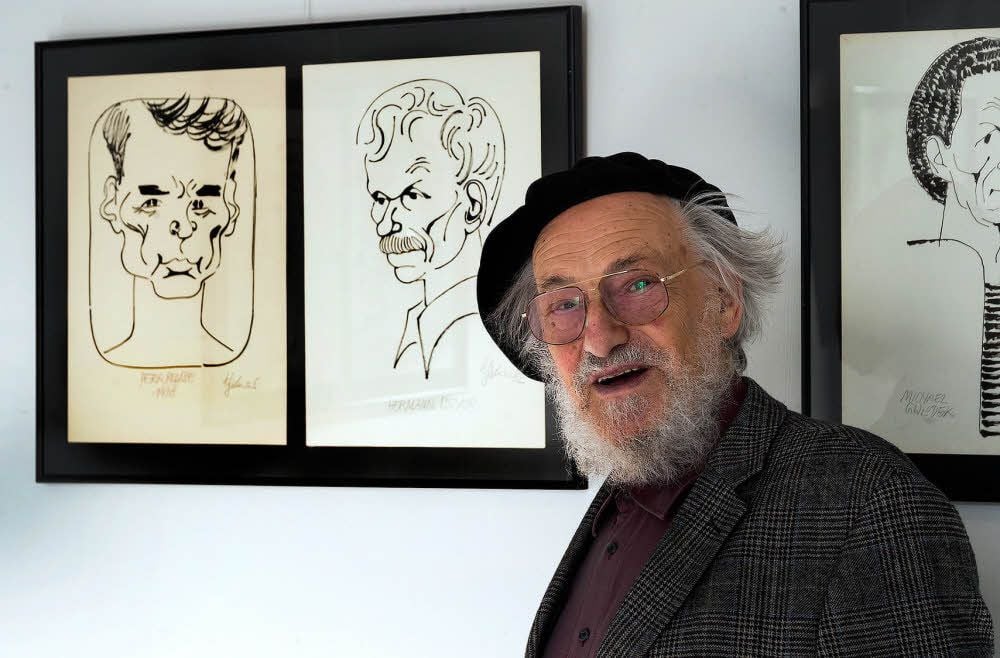 Mit dem Rücken zur Kunst: Harald Kretzschmar vor seinen Karikaturen bei einer Ausstellung in Merseburg 2013