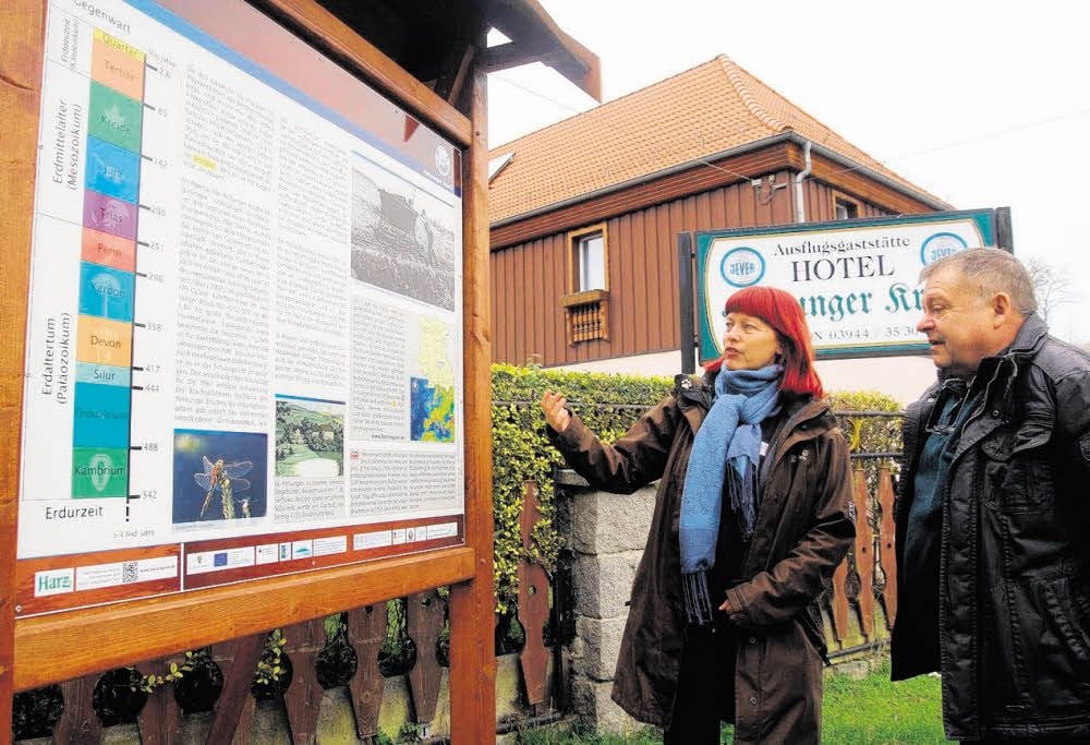 Christiane Linke vom Regionalverband Harz erläutert Gastwirt Klaus Sommer die neue Infotafel vom „Helsunger Krug“.