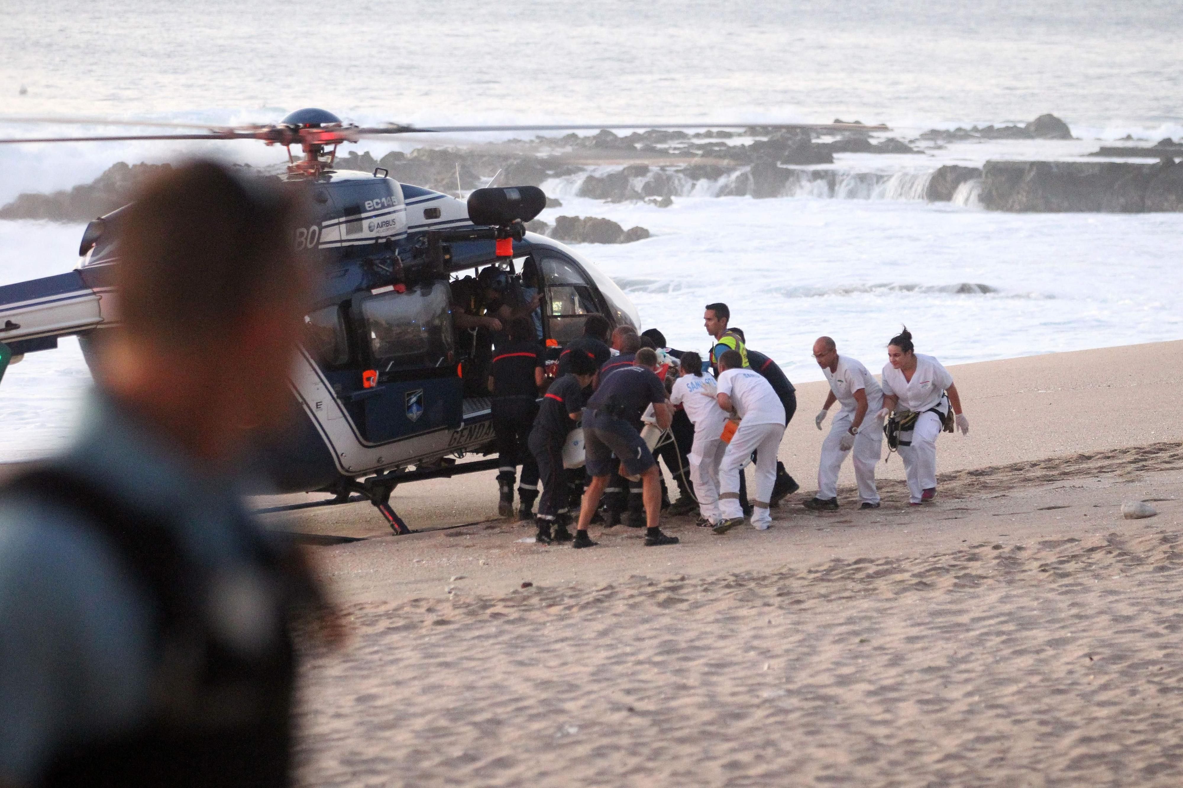 Rettungskräfte tragen den verletzten 21-Jährigen Surfer zu einem Rettungshelikopter.