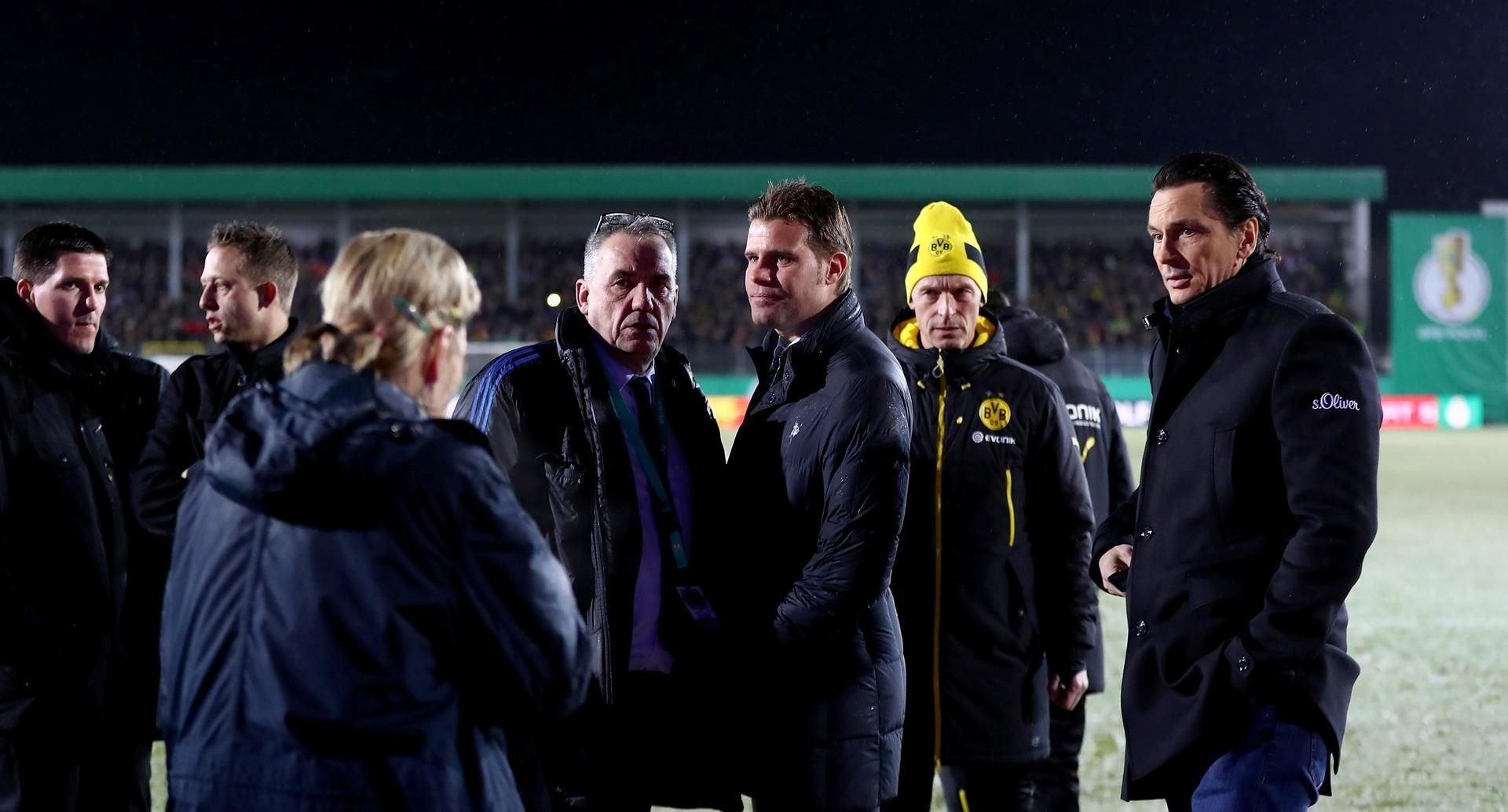 Betretene Gesichter eine Stunde vor dem geplanten Spielbeginn in Lotte: Schiedsrichter Brych (dritter von rechts) hatte zuvor die Absage des Viertelfinals beschlossen.