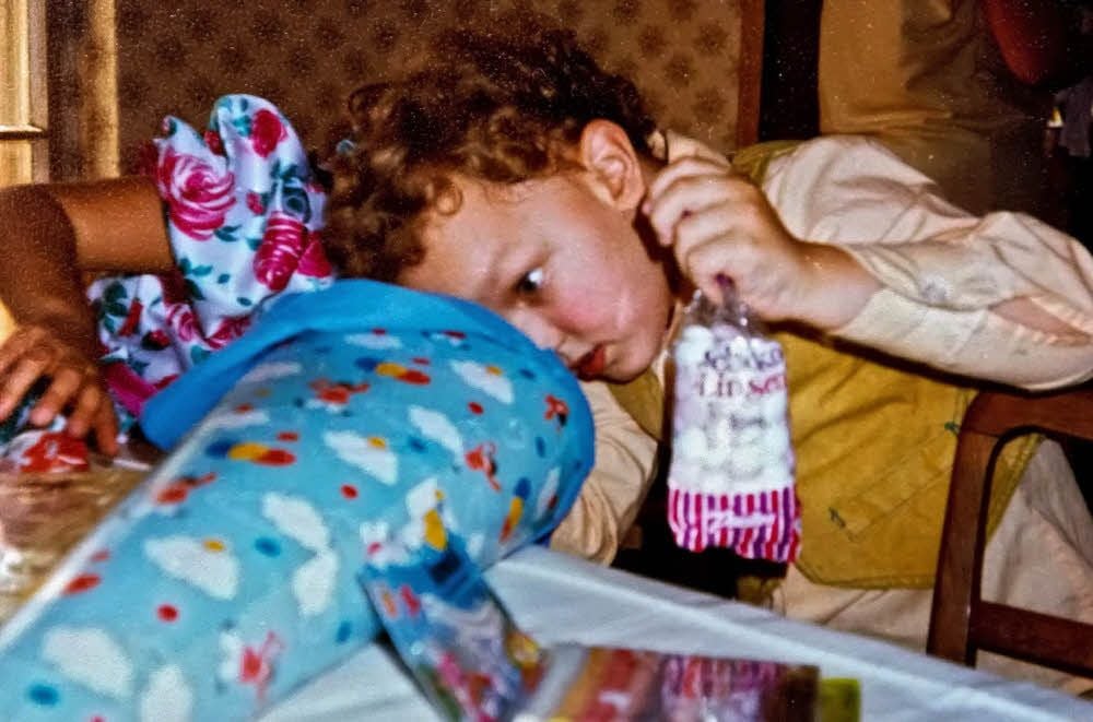Marco guckt nach seiner Einschulungsfeier 1991 neugierig in die Zuckertüte.