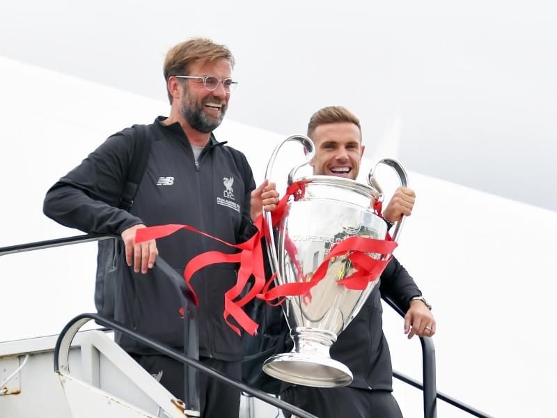 Jürgen Klopp und Jordan Henderson kommen mit der Trophäe am John Lennon Flughafen in Liverpool an. Foto: Dave Howarth/PA Wire