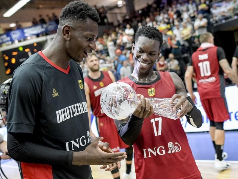 Dennis Schröder (r) und Isaac Bonga halten den Pokal in den Händen. Foto: Axel Heimken