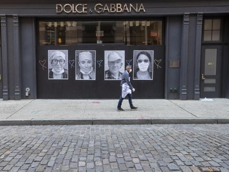 Ein Mann mit Mundschutz geht an einer geschlossenen Boutique in New York vorbei. Foto: Mary Altaffer/AP/dpa