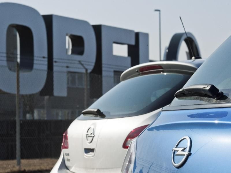 Autos stehen auf einem Parkplatz vor dem Opel-Werk in Kaiserslautern. Foto: Martin Goldhahn/Archiv