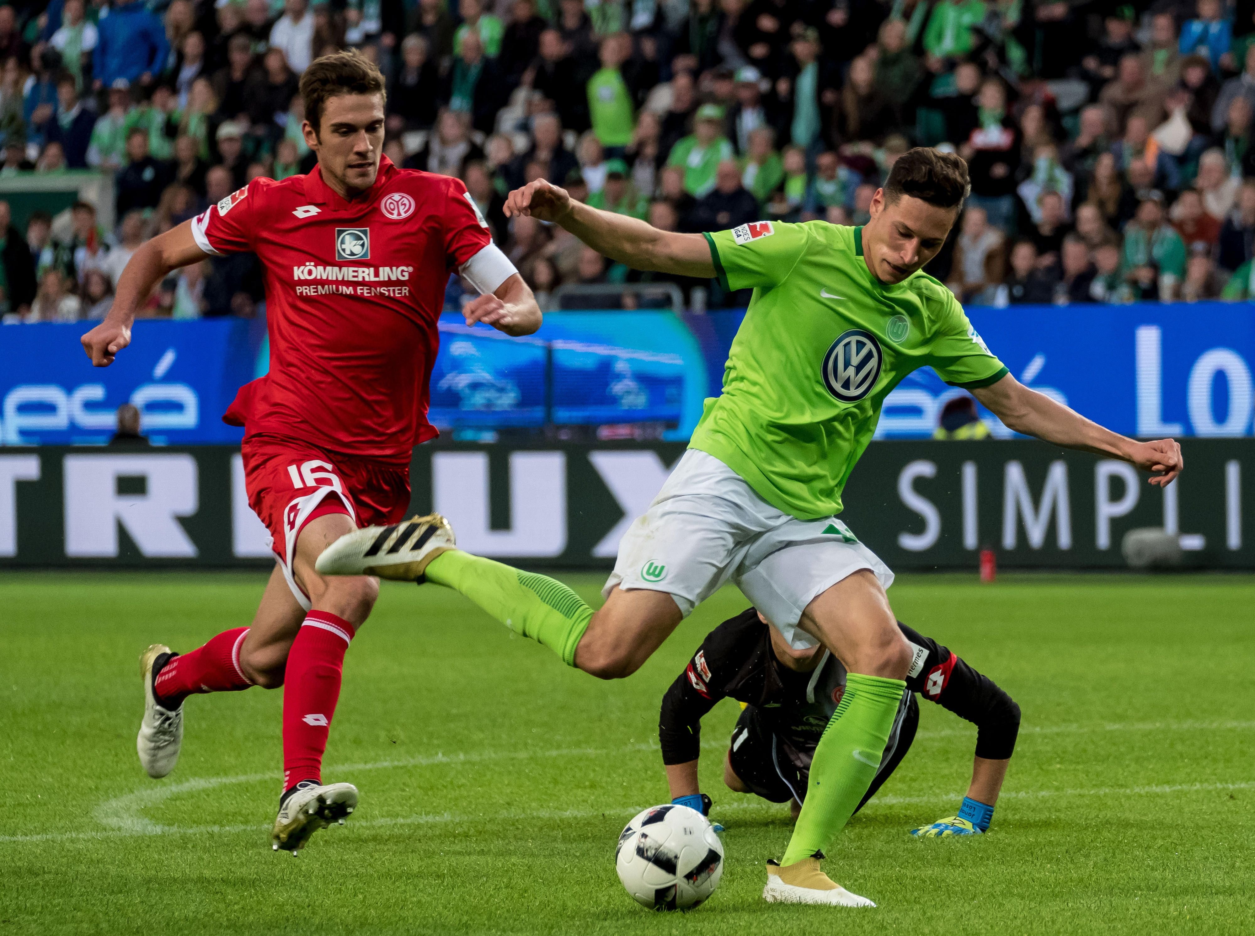 Wolfsburgs Julian Draxler (vorn) und die Mainzer Stefan Bell (hinten) und Mainzer Torwart Jonas Lössl.