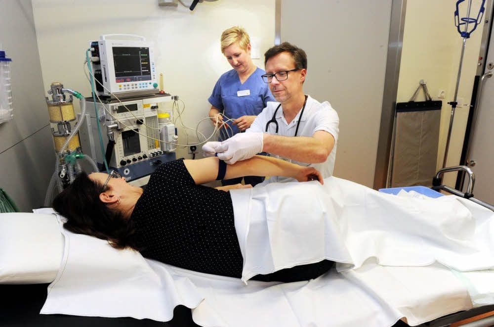 Stationsschwester Michaela Manhardt und Oberarzt Dr. Sander Jacob helfen einer Patientin.