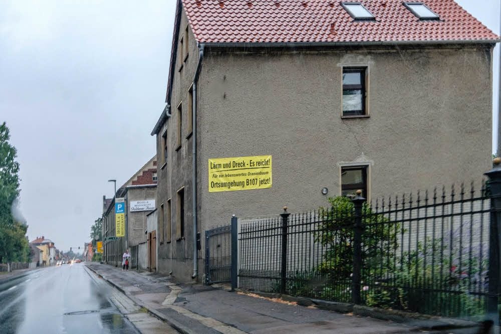 An Wänden und Zäunen machen die Bewohner auf Lärm und Dreck an der B107 aufmerksam.