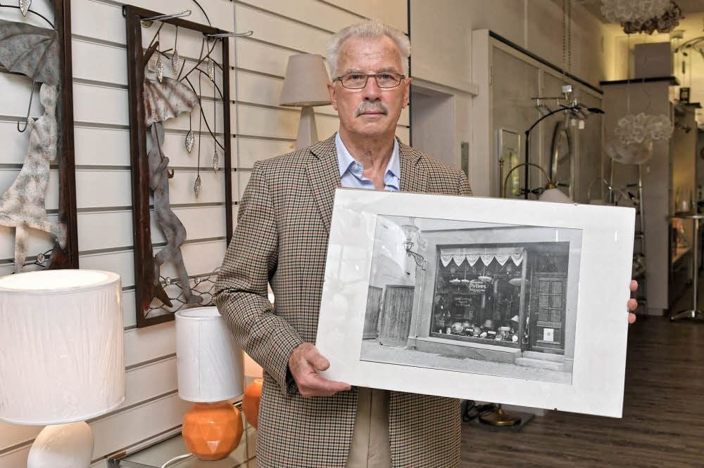 Horst Peters zeigt ein Foto des ersten Ladengeschäftes in der Marktstraße. Seit 1991 befindet sich das Fachgeschäft für Lampen und Elektrokleingeräte in der Kavalierstraße 65.
