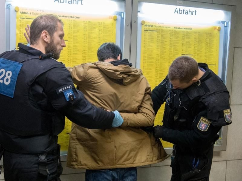 Einen verdächtigen Mann durchsuchen Polizisten. Foto: Boris Roessler