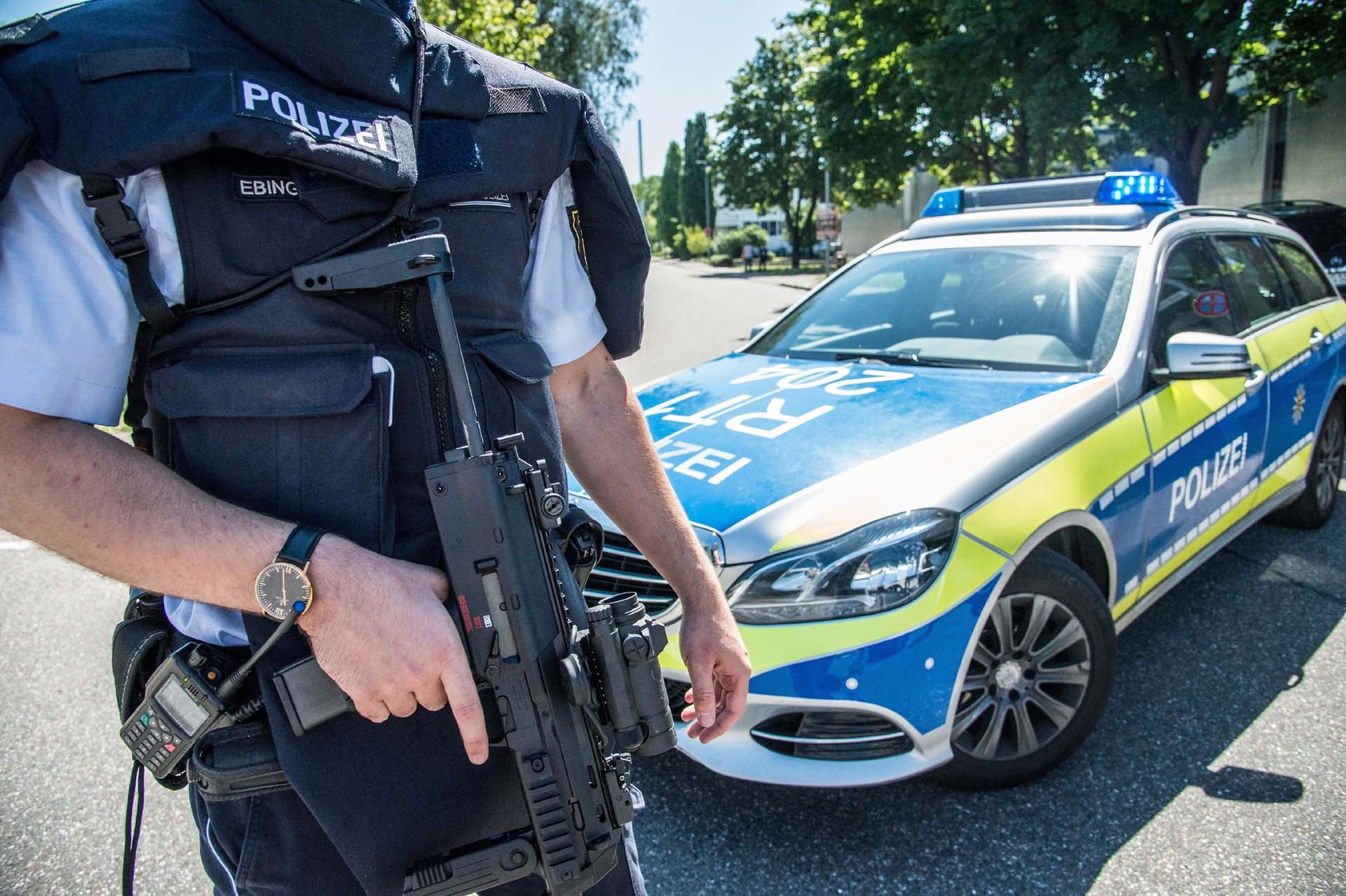 Ein Polizist steht mit seiner Waffe in Esslingen (Baden-Württemberg) auf einem Zufahrtsweg zur Friedrich-Ebert Schule.
