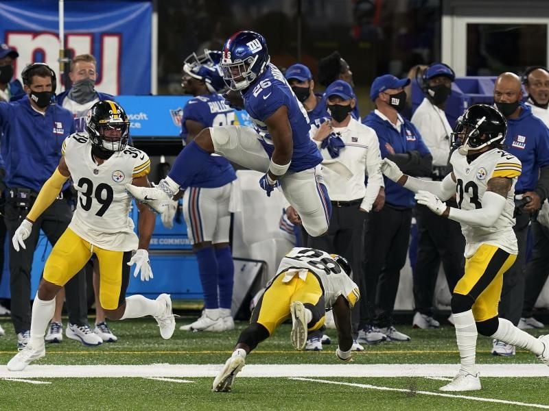 Runningback Saquon Barkley (M, oben) hat sich einen Kreuzbandriss zugezogen und fällt für die New York Giants aus. Foto: Seth Wenig/AP/dpa