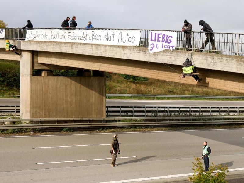 Umweltaktivisten hängen an einer Brücke über der Autobahn 3 und protestieren gegen die Rodung von Bäumen im Herrenwald und Dannenröder Forst bei Stadtallendorf im Zusammenhang mit dem geplanten Ausbau der Autobahn 49. Foto: Jörg Halisch/dpa/Archivbild