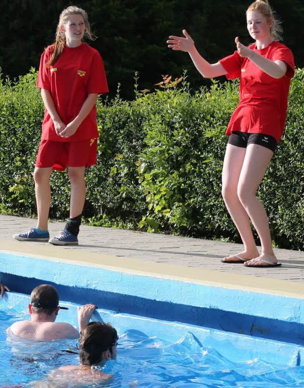 Antonia Leutritz (links) und Michelle Wurche erklären am Beckenrand, was die Trainingsteilnehmer als nächstes machen sollen.