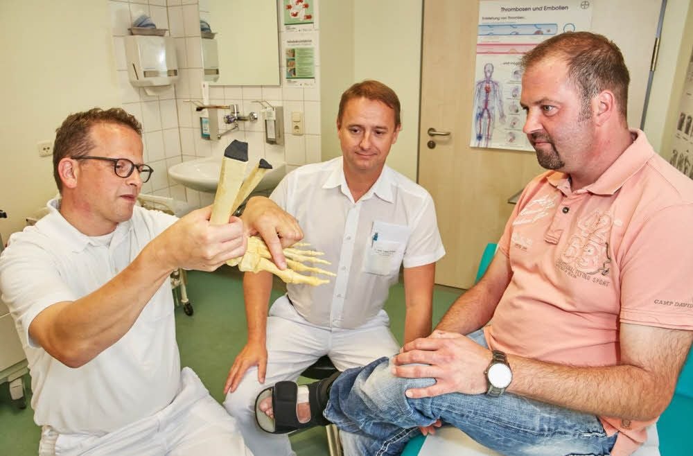 Ralph Ludwig (l.) erklärt Norman Skubich (r.) mit seinem Kollegen Tobias Schaaf das Fußmodell.