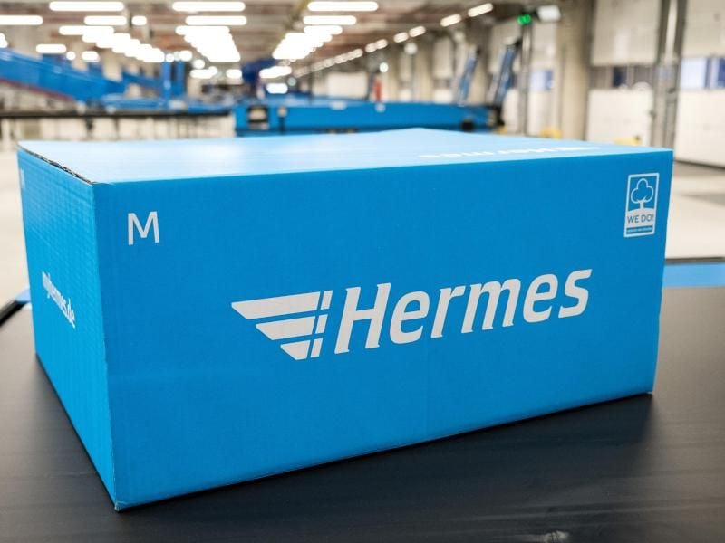 Ein Hermes-Paket liegt auf einem Förderband. Foto: Daniel Bockwoldt/dpa/Symbolbild