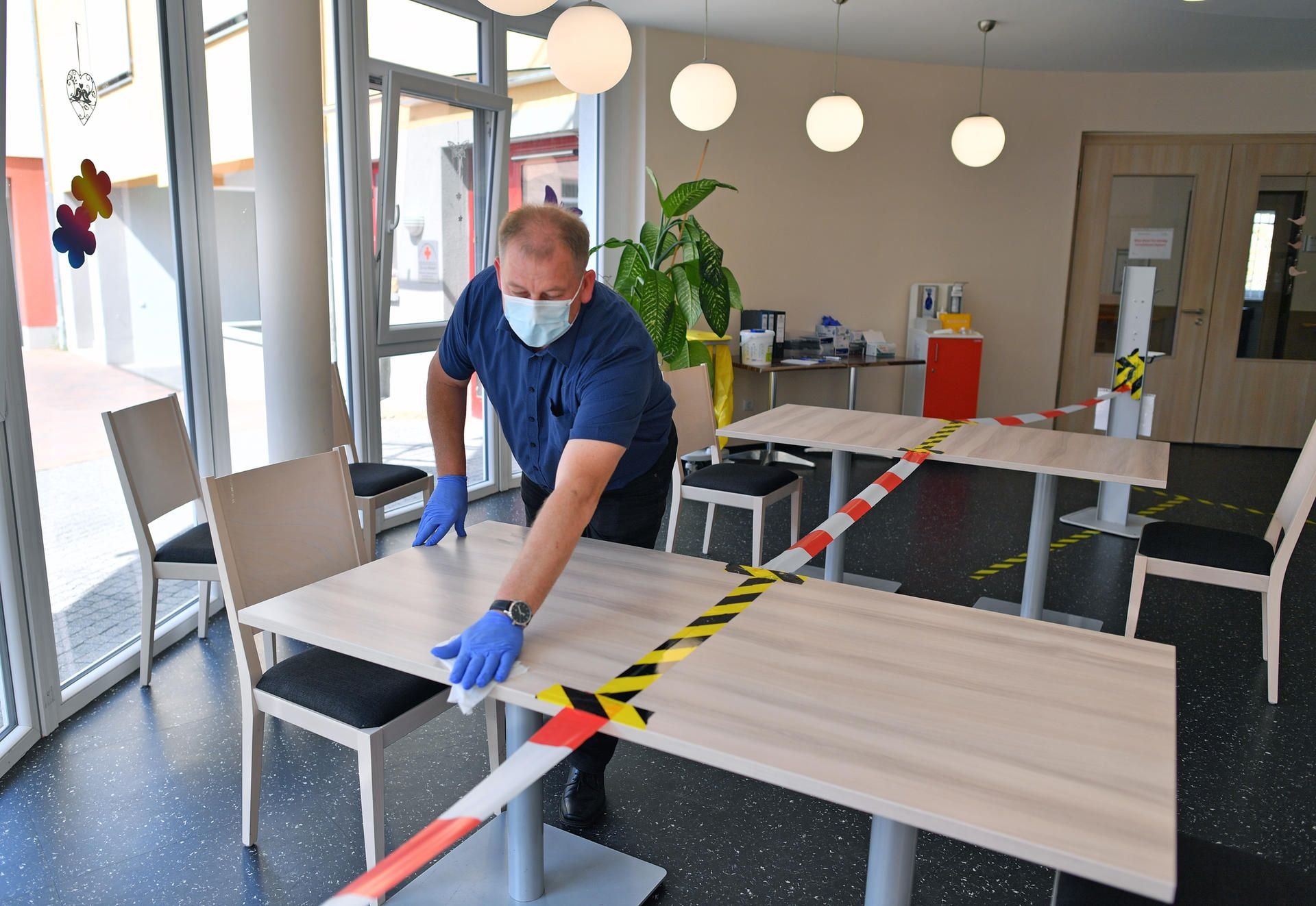 Dirk Betker, Einrichtungsleiter, desinfiziert einen Tisch in der Kantine des DRK Pflege- und Betreuungszentrums "Tor zur Altstadt" in Sangerhausen.