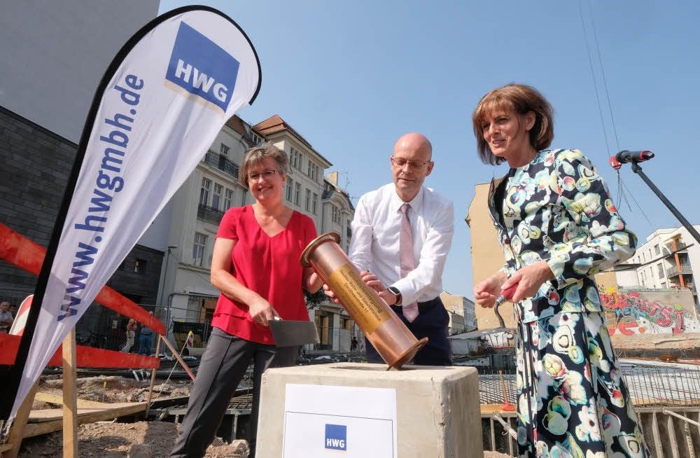 Von links: Angela Papenburg, OB Bernd Wiegand und HWG-Prokuristin Simone Danz versenken die Kapsel im Grundstein.