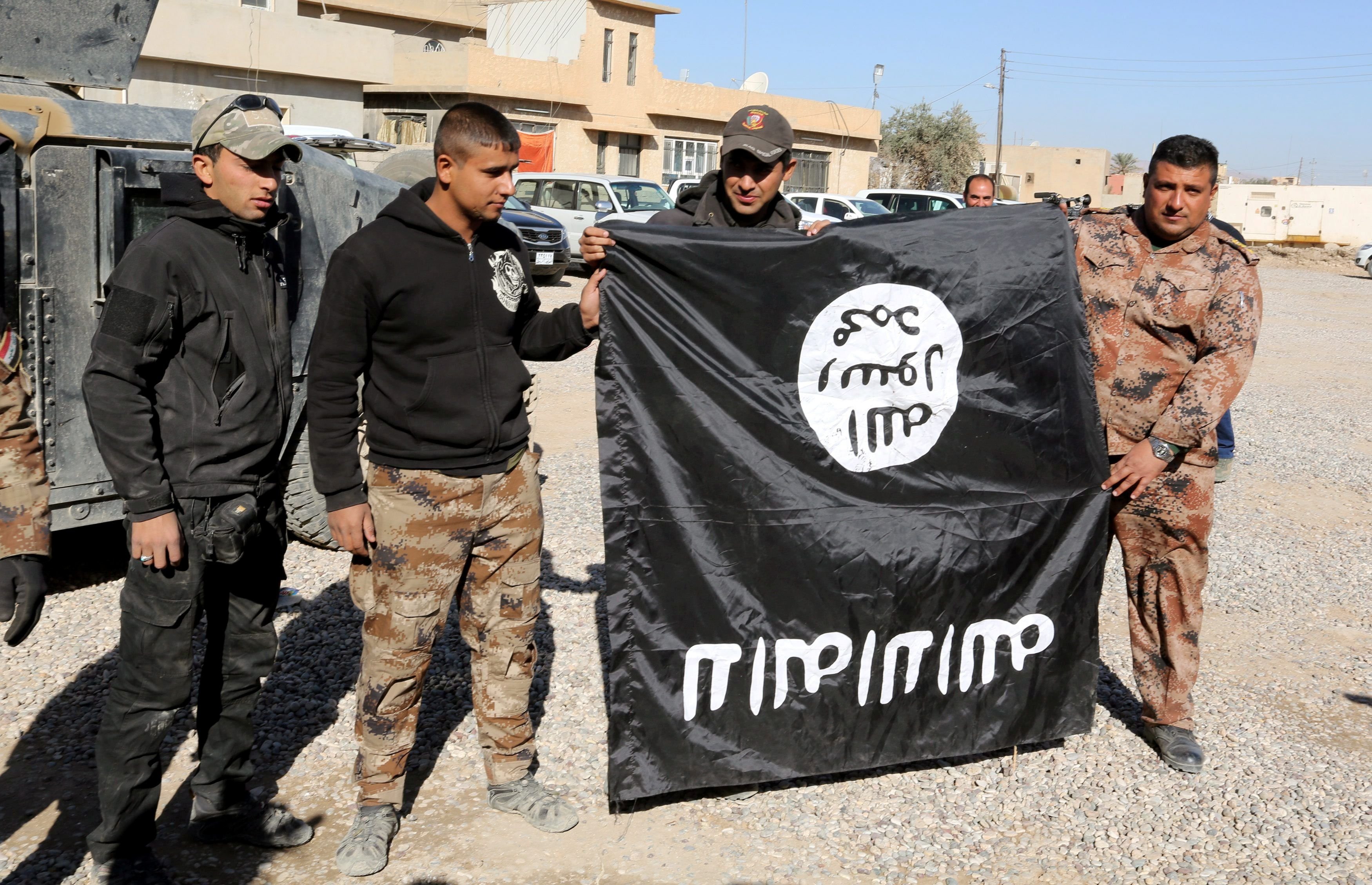 Irakische Soldaten zeigen eine eroberte IS-Flagge.