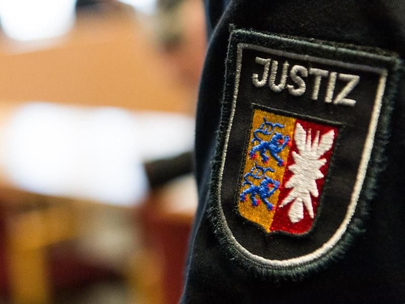 Ein Aufnäher eines Justizbeamten, aufgenommen im Landgericht. Foto: Christophe Gateau/Archiv