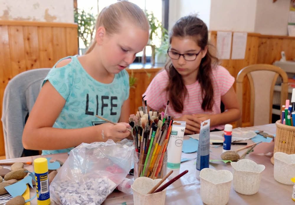 Lilly Lucia Brenicke (links) und Melina Täubner gehören mit zu den Kurs-Teilnehmern. Sie bemalen ihre Steine mit Tiermotiven.