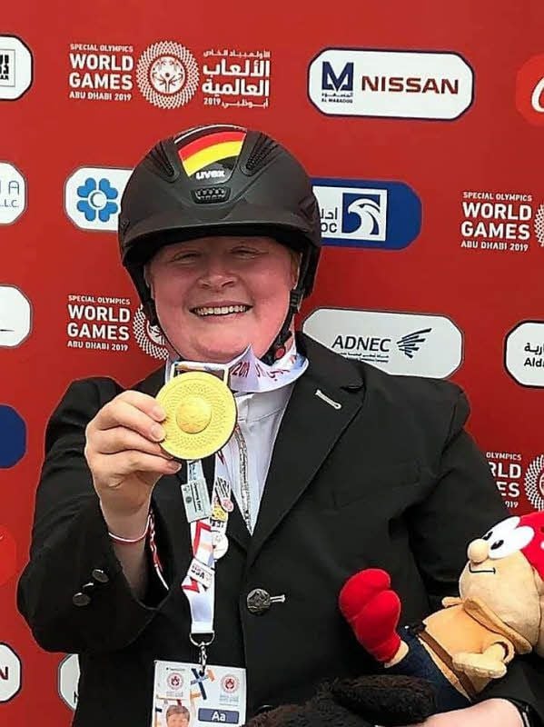Juliane Dietrich zeigt voller Stolz eine ihrer Goldmedaillen im Dressurreiten.