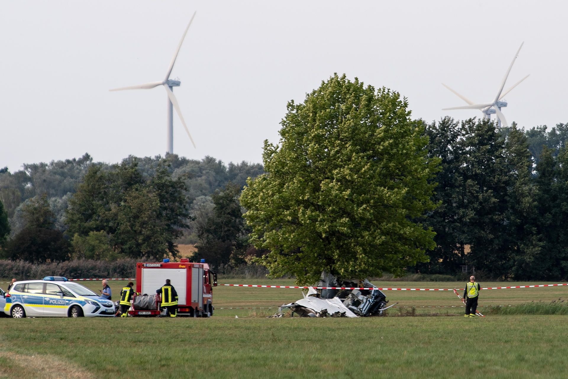 Zehdenick: Einsatzkräfte der Feuerwehr und der Polizei stehen nach dem Absturz von einem Kleinflugzeug auf einem Feld zwischen dem Ortsteil Badingen und Gransee.