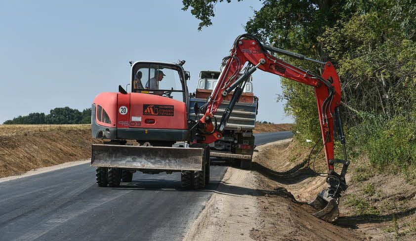 Bevor die Deckschicht auf die Fahrbahn aufgebracht wird, laufen noch Profilierungsarbeiten an Straßengräben und Banketten.